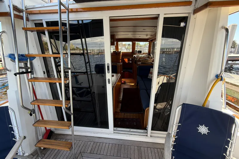  Yacht Photos Pics 1999 Sabreline 34 Flybridge yacht with wooden steps and glass doors, docked by the water.