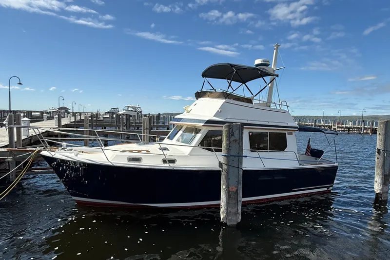  Yacht Photos Pics 1999 Sabreline 34 Flybridge boat docked at marina under clear blue sky.
