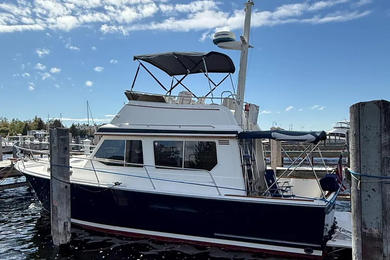  Yacht Photos Pics 1999 Sabreline 34 Flybridge boat docked at marina under clear blue sky.