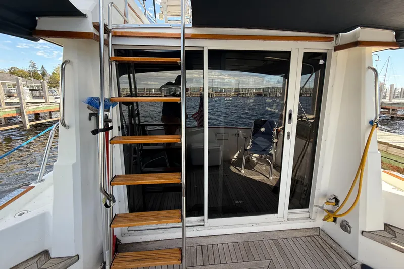  Yacht Photos Pics 1999 Sabreline 34 Flybridge yacht with wooden steps and sliding glass doors.