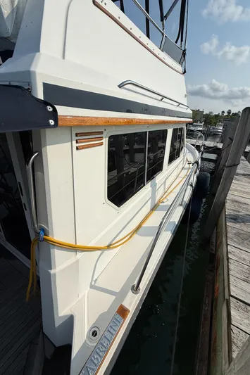  Yacht Photos Pics 1999 Sabreline 34 Flybridge yacht docked, showcasing sleek design and exterior details.