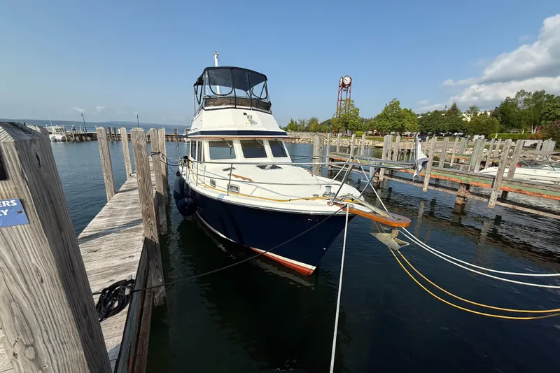  Yacht Photos Pics 1999 Sabreline 34 Flybridge yacht docked at a marina on a sunny day.