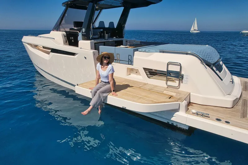  Yacht Photos Pics Woman relaxing on a 2025 Cayman Yachts 380 WA, enjoying the serene ocean view.