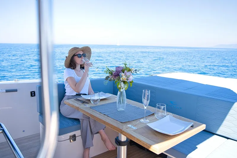  Yacht Photos Pics Woman relaxing on Cayman Yachts 380 WA, enjoying a drink with ocean view, 2025 model.