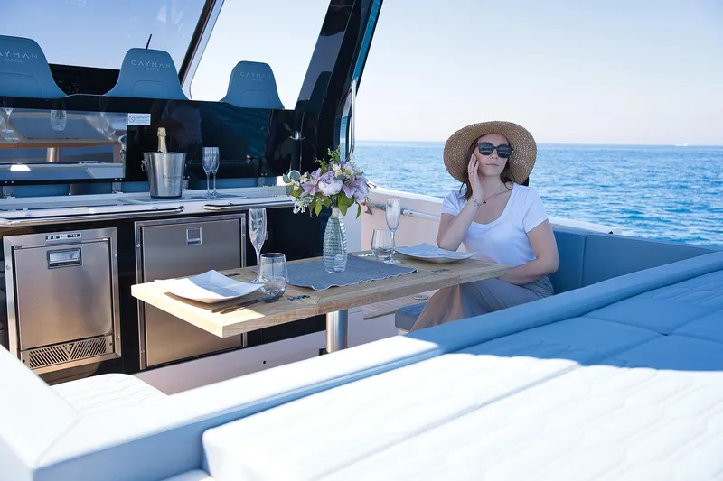  Yacht Photos Pics Woman relaxing on 2025 Cayman Yachts 380 WA, enjoying a sunny day at sea.