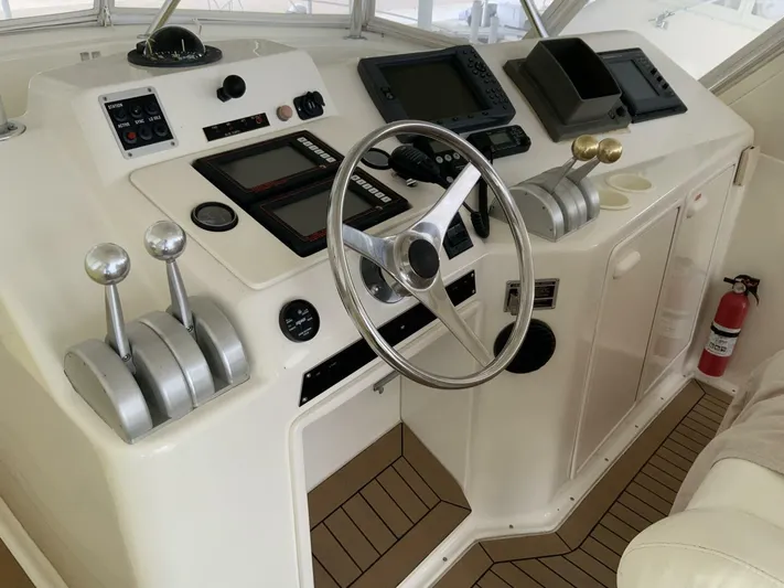 Bona Vida Yacht Photos Pics 1997 Ocean Yachts 48 Convertible helm with steering wheel, controls, and navigation equipment.