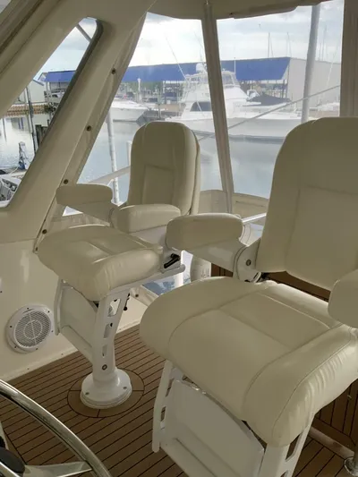 Bona Vida Yacht Photos Pics 1997 Ocean Yachts 48 Convertible interior with plush captain chairs and marina view.