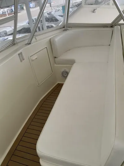 Bona Vida Yacht Photos Pics 1997 Ocean Yachts 48 Convertible boat interior with white seating and wood flooring.