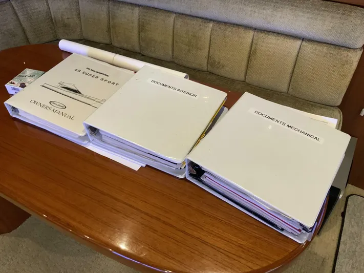 Bona Vida Yacht Photos Pics Binders and manuals on a table inside a 1997 Ocean Yachts 48 Convertible.