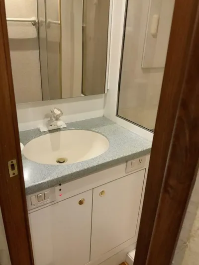 Bona Vida Yacht Photos Pics Bathroom vanity in 1997 Ocean Yachts 48 Convertible, featuring sink and mirror.