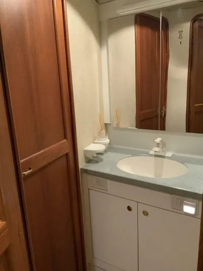 Bona Vida Yacht Photos Pics Bathroom interior of 1997 Ocean Yachts 48 Convertible with wooden cabinetry and modern sink.