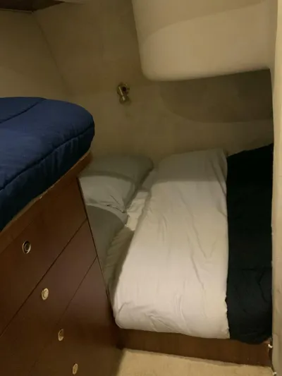 Bona Vida Yacht Photos Pics 1997 Ocean Yachts 48 Convertible cabin with cozy bedding and wooden storage drawers.