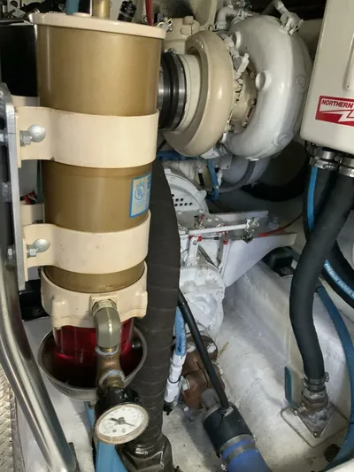 Bona Vida Yacht Photos Pics Engine room of 1997 Ocean Yachts 48 Convertible, showcasing mechanical components and piping.