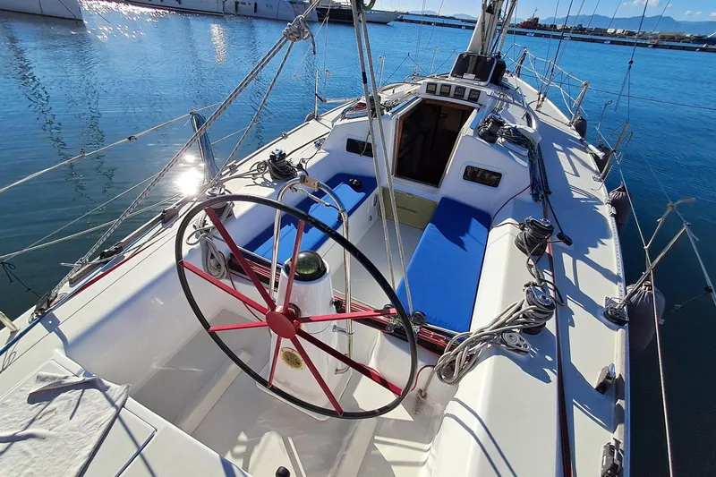  Yacht Photos Pics 1999 J Boats J/120 sailboat cockpit with red steering wheel, docked in sunny marina.