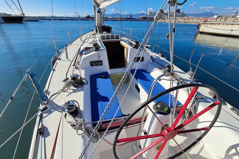  Yacht Photos Pics 1999 J Boats J/120 sailboat cockpit with blue seating and steering wheel in marina.