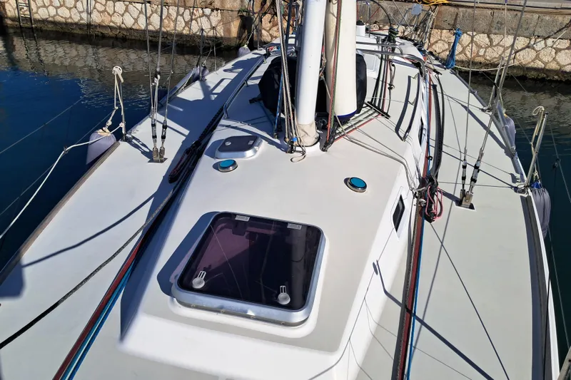  Yacht Photos Pics 1999 J Boats J/120 sailboat deck with rigging and hatch, docked by stone wall.