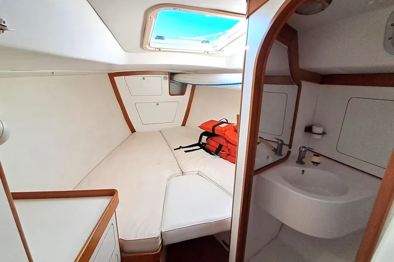  Yacht Photos Pics 1999 J Boats J/120 cabin interior with bed, sink, and life jackets.