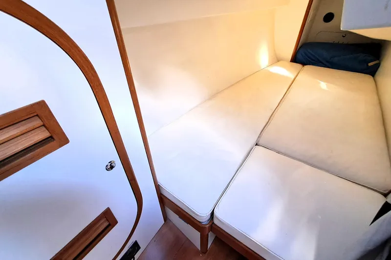  Yacht Photos Pics 1999 J Boats J/120 cabin interior with white cushions and wooden accents.