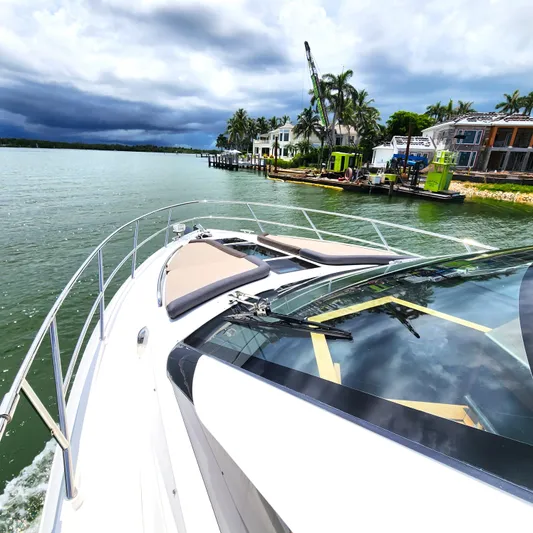 Makers Time Yacht Photos Pics 2018 Galeon 430 HTC yacht cruising near waterfront homes under cloudy skies.