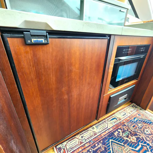 Makers Time Yacht Photos Pics Luxurious 2018 Galeon 430 HTC yacht kitchen with wooden cabinetry and modern appliances.