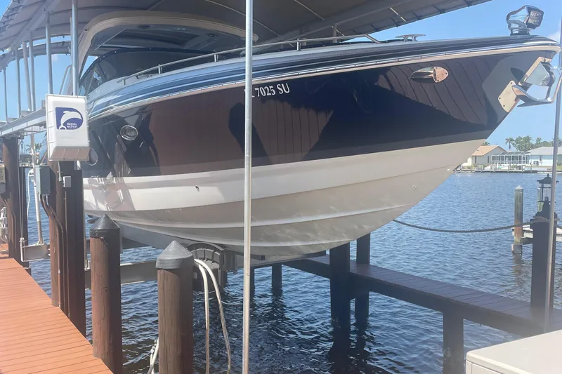  Yacht Photos Pics 2020 Formula 350 Crossover Bowrider OB on a boat lift by the water.