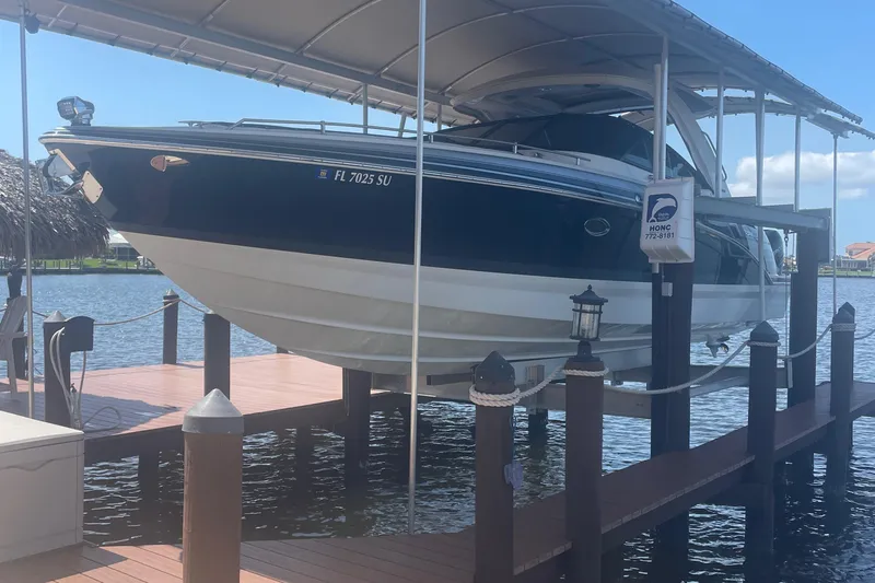  Yacht Photos Pics 2020 Formula 350 Crossover Bowrider OB on a boat lift at a dock.