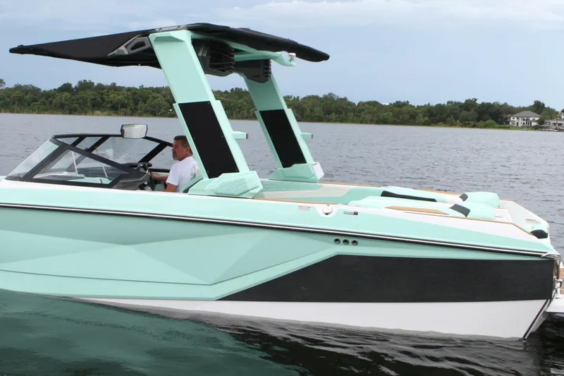  Yacht Photos Pics 2024 Nautique Super Air Nautique G23 boat on calm water, featuring sleek design and modern features.