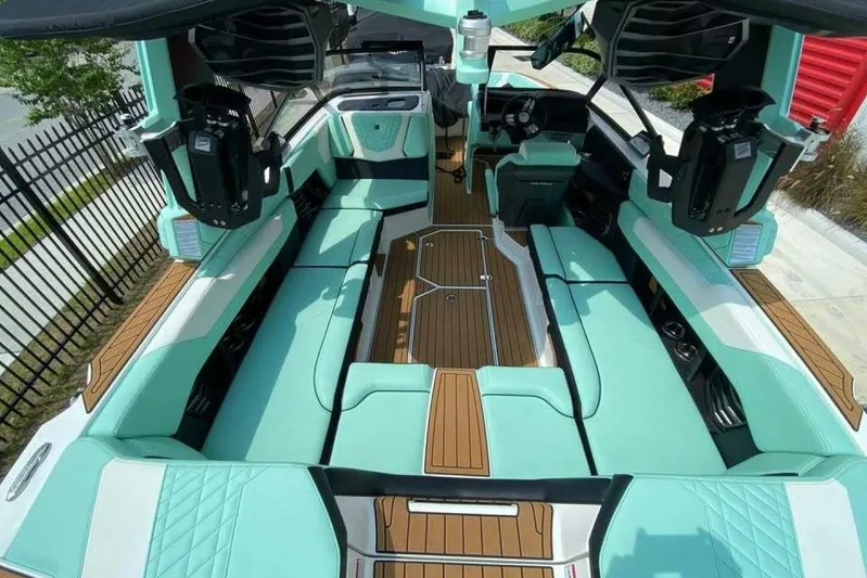  Yacht Photos Pics 2024 Nautique Super Air Nautique G23 interior with teal seating and wood accents.