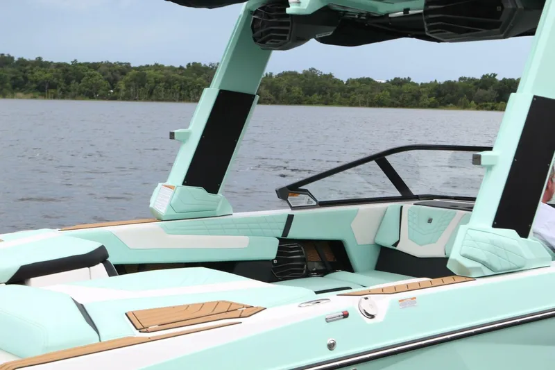  Yacht Photos Pics 2024 Nautique Super Air Nautique G23 boat interior with mint green accents on a lake.