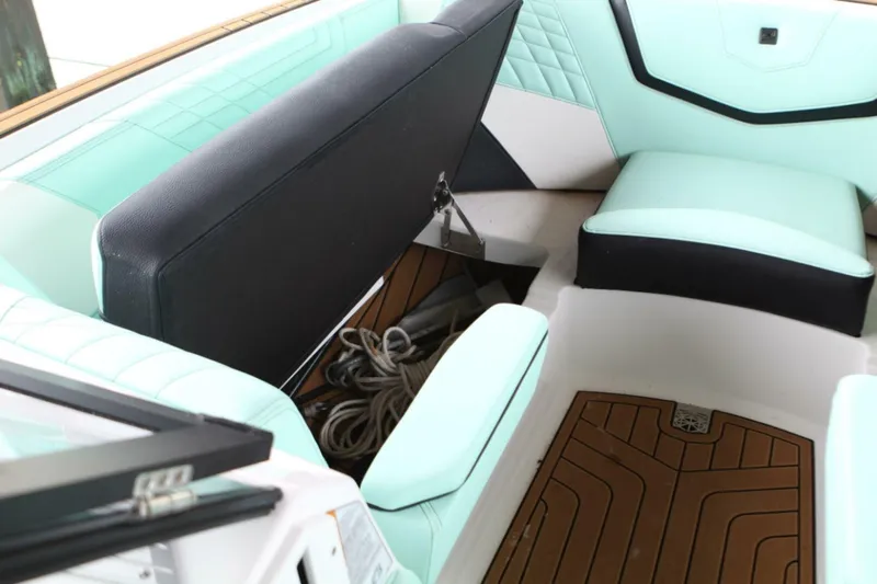  Yacht Photos Pics 2024 Nautique Super Air Nautique G23 interior seating with storage compartment open.