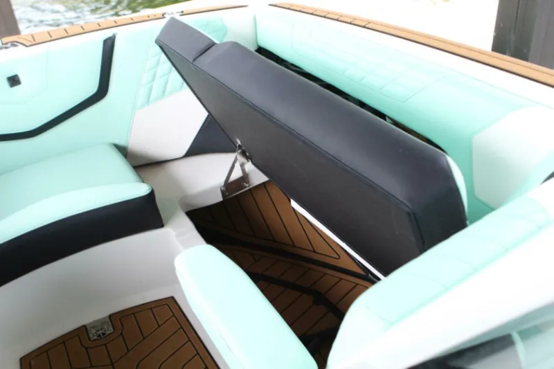  Yacht Photos Pics 2024 Nautique Super Air Nautique G23 interior with mint and black seating, storage compartment open.