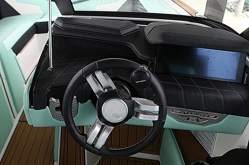  Yacht Photos Pics 2024 Nautique Super Air Nautique G23 dashboard with steering wheel and touchscreen display.