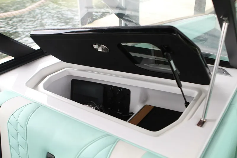  Yacht Photos Pics 2024 Nautique Super Air Nautique G23 storage compartment with open lid, showcasing interior details.