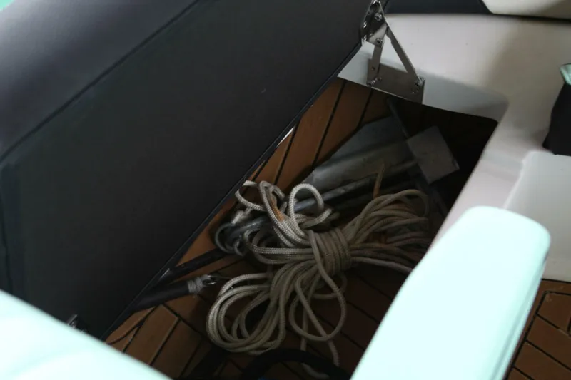  Yacht Photos Pics Storage compartment in 2024 Nautique Super Air Nautique G23 with coiled rope and anchor.