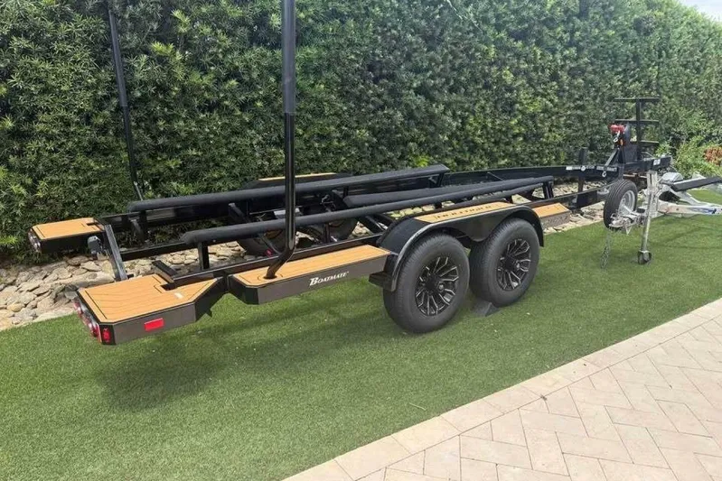  Yacht Photos Pics Trailer for 2024 Nautique Super Air Nautique G23 on grass, near hedge.