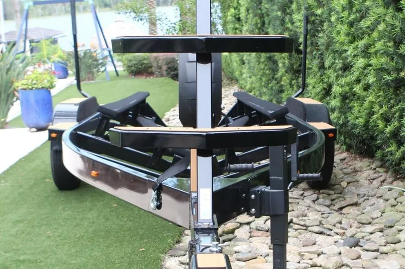  Yacht Photos Pics 2024 Nautique Super Air Nautique G23 trailer on a landscaped path.