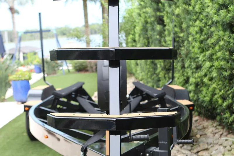  Yacht Photos Pics 2024 Nautique Super Air Nautique G23 boat trailer in a lush garden setting.