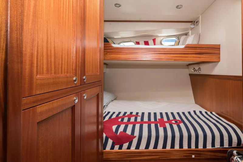 Take 2 Yacht Photos Pics Cozy cabin interior of 2015 Nordic Tug 44 with wooden finish and nautical bedding.