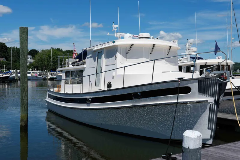 Take 2 Yacht Photos Pics 2015 Nordic Tug 44 docked at a marina under a clear blue sky.