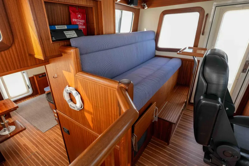 Take 2 Yacht Photos Pics Interior of 2015 Nordic Tug 44 with blue seating and wooden accents.