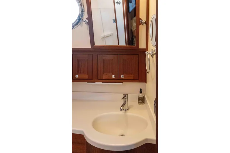 Take 2 Yacht Photos Pics Bathroom interior of 2015 Nordic Tug 44 with wooden cabinets and round sink.