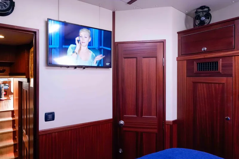 Take 2 Yacht Photos Pics Interior of 2015 Nordic Tug 44 with TV, wooden cabinetry, and cozy furnishings.