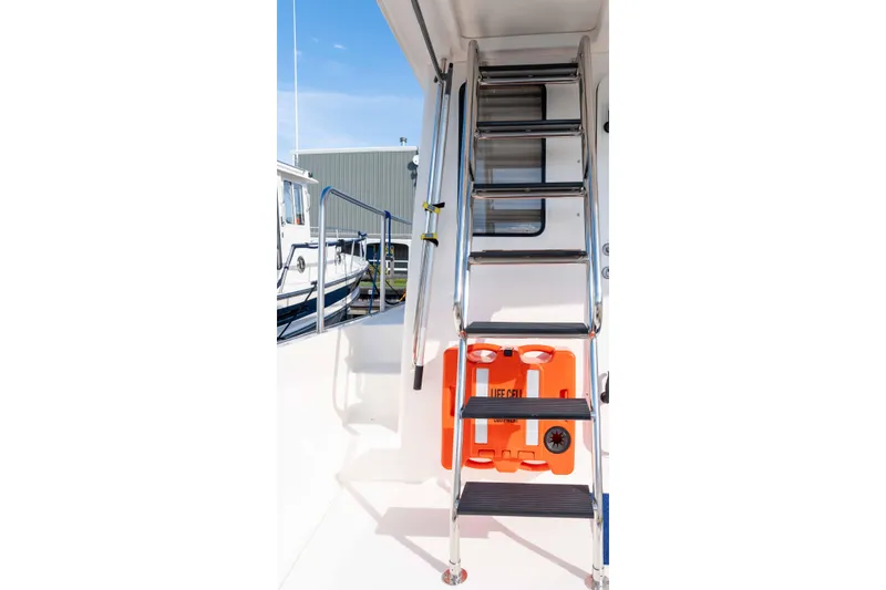 Take 2 Yacht Photos Pics Stainless steel ladder on 2015 Nordic Tug 44 with visible lifebuoy.