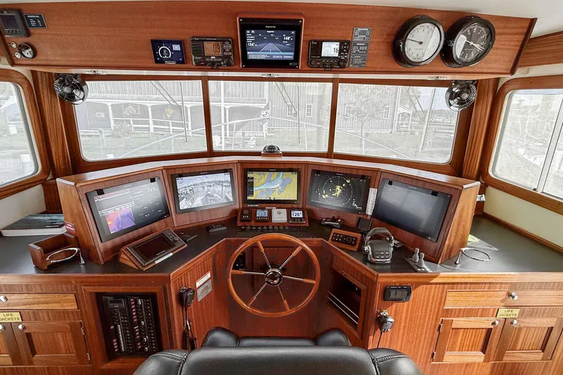 Take 2 Yacht Photos Pics Pilothouse of 2015 Nordic Tug 44 with navigation equipment and wooden interior.
