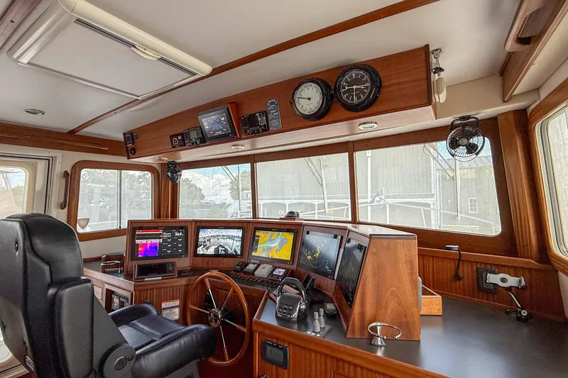 Take 2 Yacht Photos Pics Pilothouse interior of 2015 Nordic Tug 44 with navigation equipment and wooden accents.