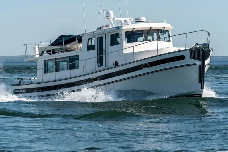 Take 2 Yacht Photos Pics 2015 Nordic Tug 44 cruising on open water, showcasing sleek design and powerful performance.