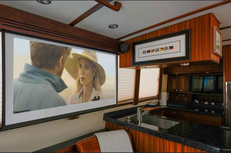 Take 2 Yacht Photos Pics Interior of 2015 Nordic Tug 44 with a movie playing on a screen.