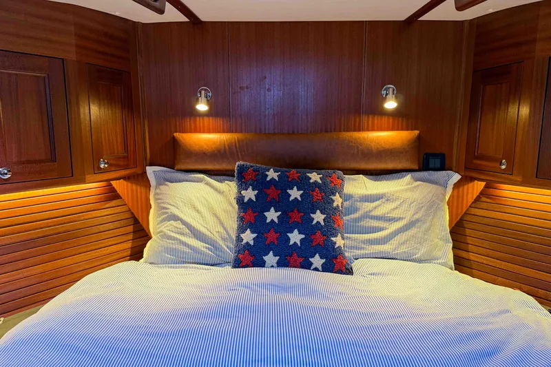 Take 2 Yacht Photos Pics Cozy bedroom in 2015 Nordic Tug 44 with wood paneling and star-patterned pillow.