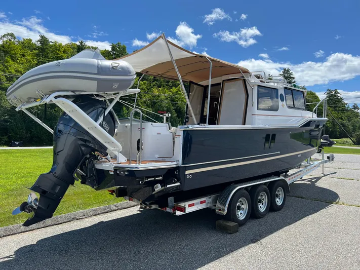  Yacht Photos Pics 2024 Ranger Tugs R-27 boat on trailer with canopy and outboard motor.