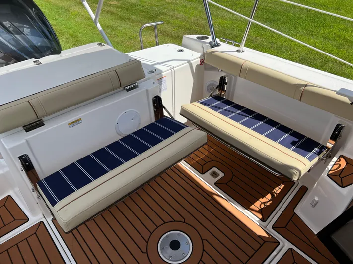  Yacht Photos Pics 2024 Ranger Tugs R-27 boat interior with foldable seats and teak flooring.